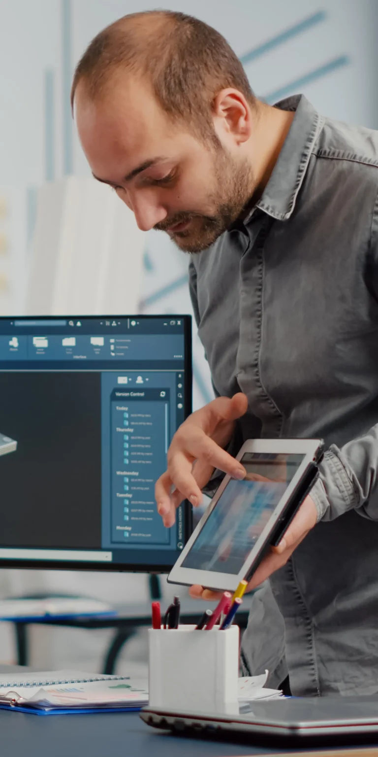 Developer using a tablet alongside a 3D modeling interface—illustrating how Scorpion Five Technologies creates advanced software tailored to complex, specialized workflows.