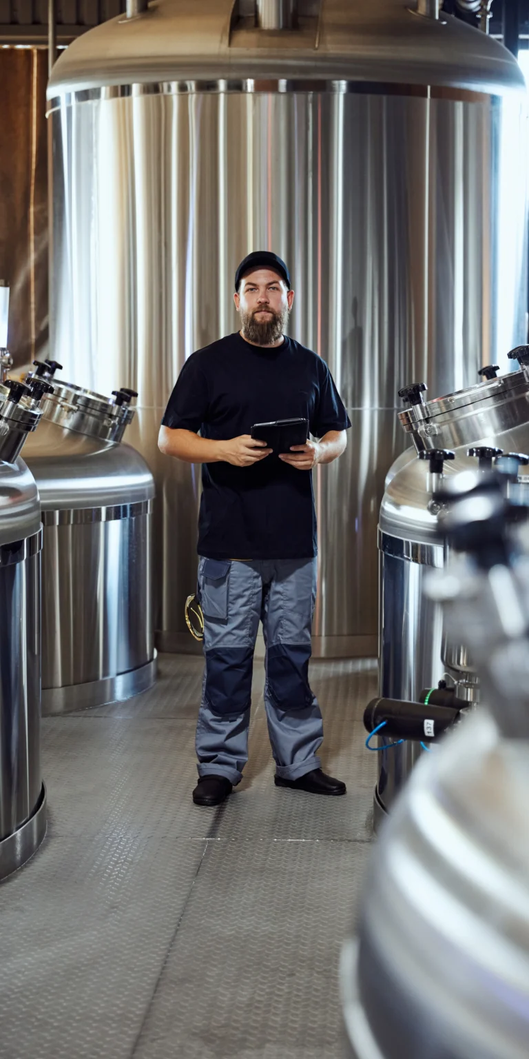 A brewing technologist carries a tablet, symbolizing the connection between business process automation and this small business' craft beer products.