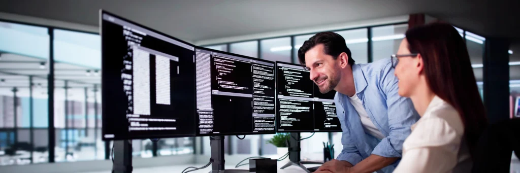 Developers collaborating on modular backend code across multiple screens—showcasing Scorpion Five Technologies (S5T) engineers microservices development capabilities.