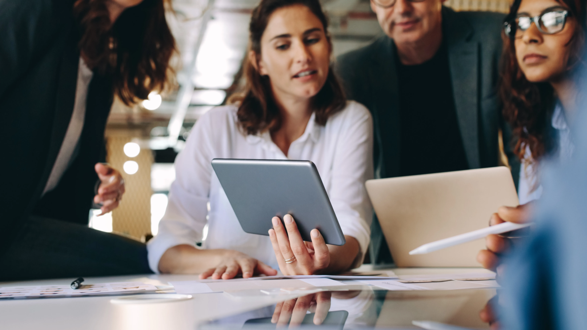 Small business team reviewing a tablet during a strategy session with Scorpion Five Technologies—discussing the benefits and challenges of developing custom software solutions for small business operations.