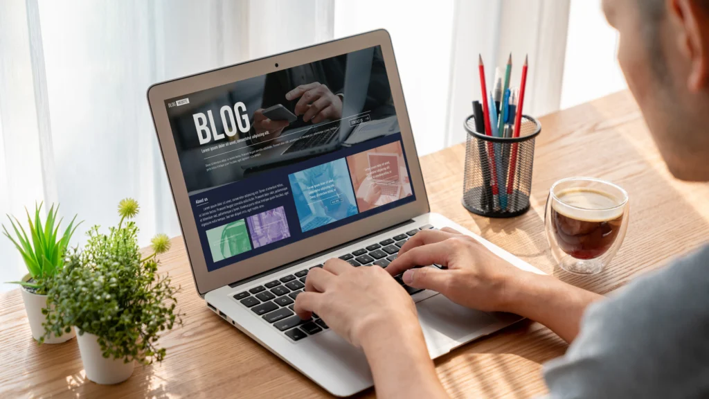 Small business owner writing a blog post on a laptop, illustrating inbound marketing strategies like content creation and SEO that build long-term growth.