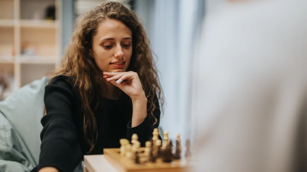 Woman playing chess and planning her next move, symbolizing the strategic planning needed to build a balanced online marketing gameplan for small business.